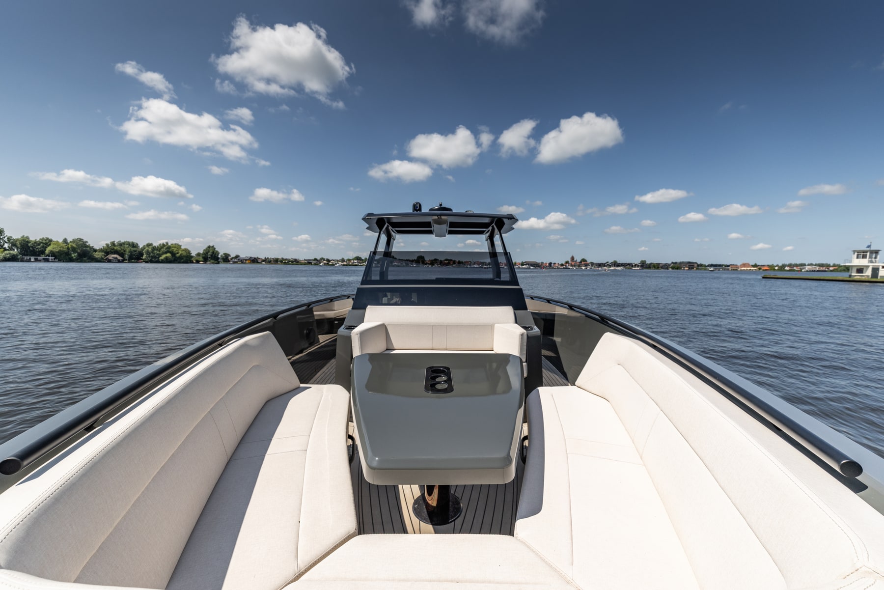 Voordek van een motorjacht met zitkussens op het water