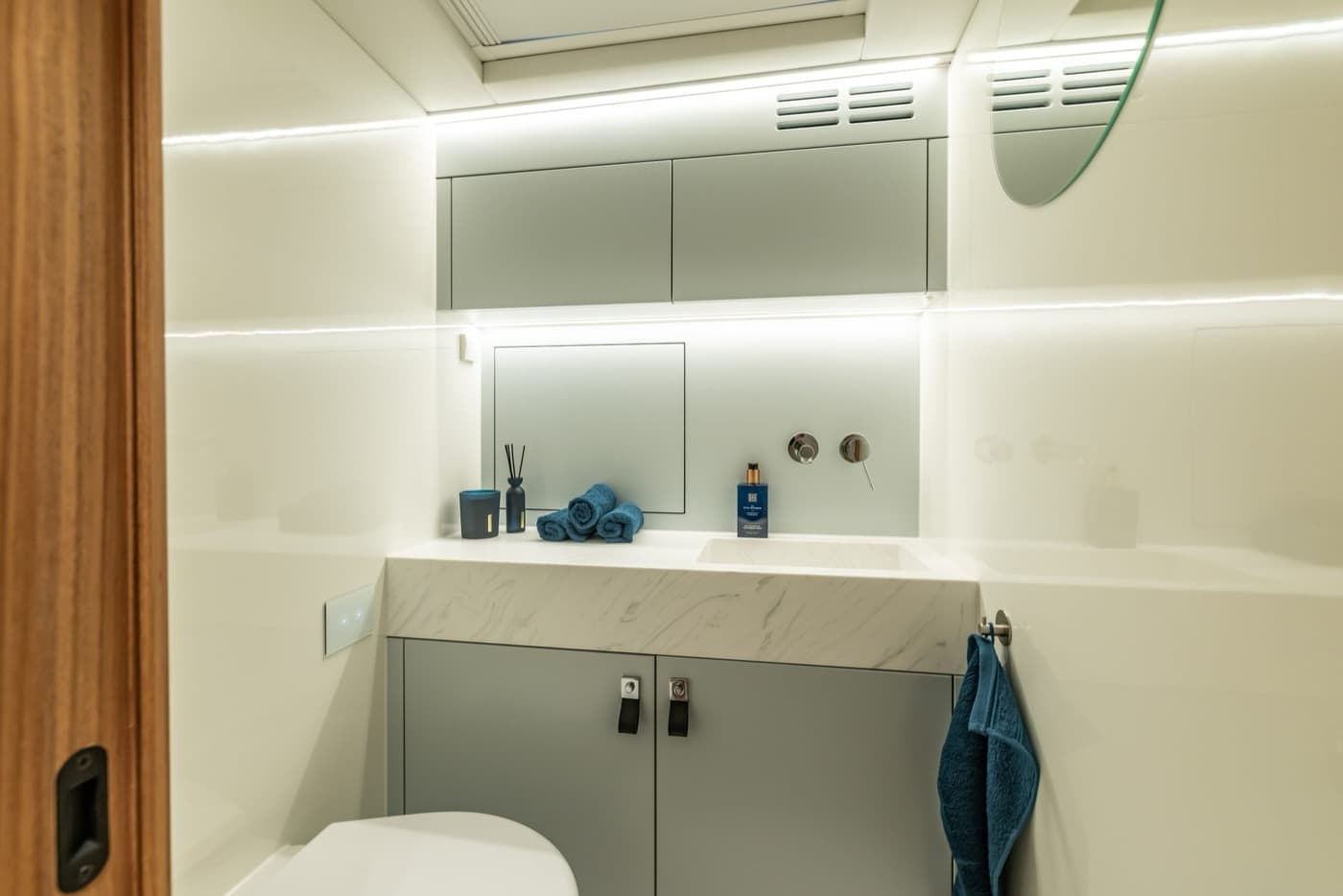 Bathroom with Corian washbasin and lit mirror cabinet